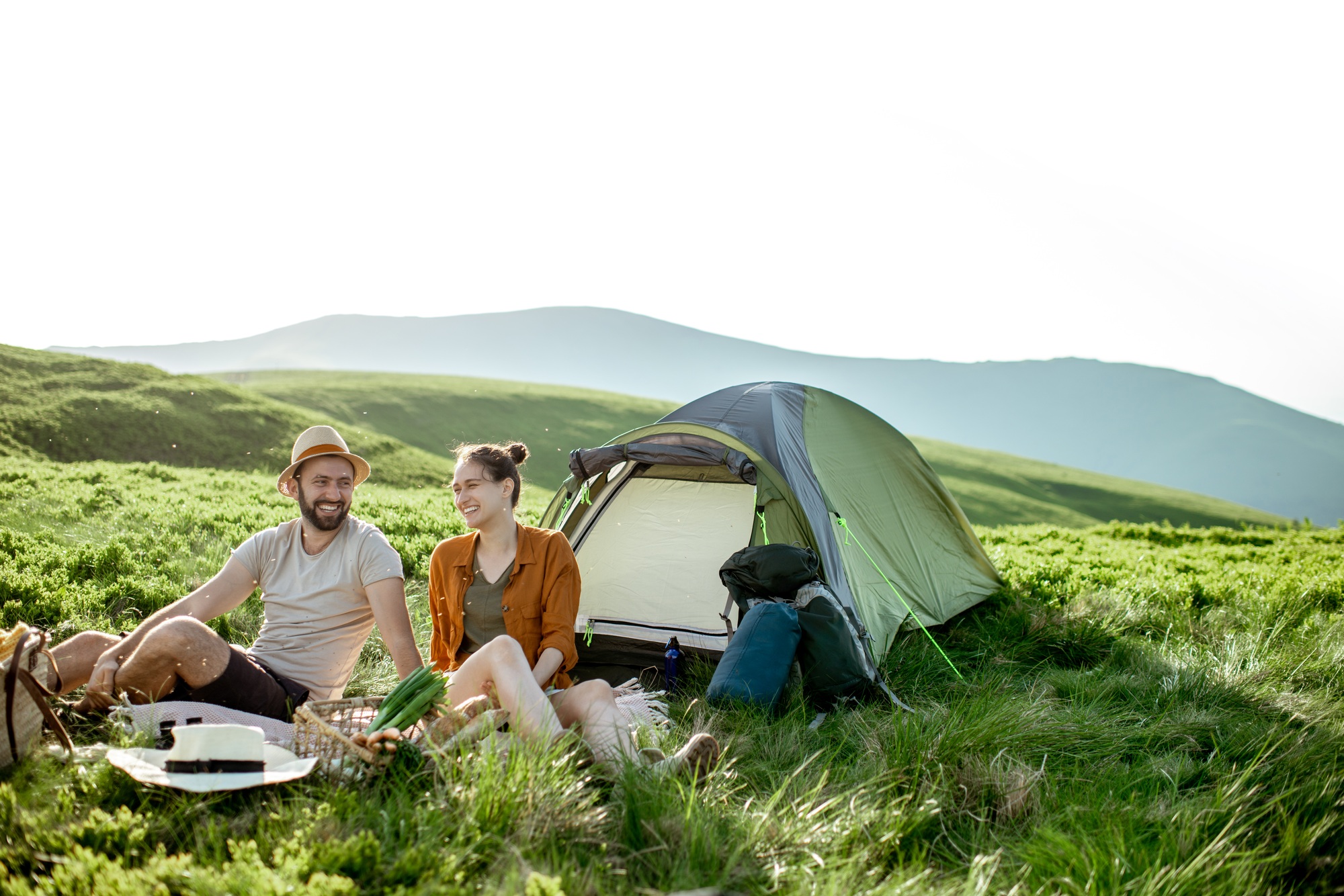 couple-having-a-picnic-near-the-tent-in-the-mountains.jpg